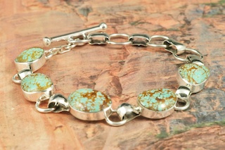 5 Beautiful Genuine Number 8 Mine Turquoise Stones set in Sterling Silver Bracelet. Created by Navajo Artist Tony Garcia. Signed by the artist. The Number 8 mine is located in Eureka County Nevada. Since 1976 there has been no Number 8 Turquoise mined. There is however, an existing stock pile that Mr. Dowell Ward, the last owner of the Number 8 mine, had stocked away for later sorting. The Turquoise is a collector's item--because once the reserve is gone there will be no more material released onto the market. The Gold Mining Company owns the claim to the Number 8 mine and it has been swallowed up by the gold mining operations. This is some of the last Number 8 Turquoise to be had and will be a great addition to your collection.